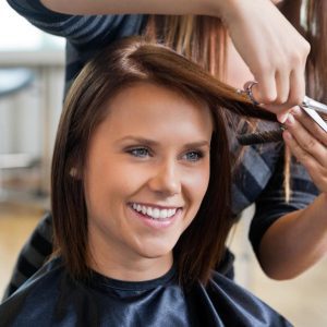 Photo of woman with long brown hair getting her hair cut